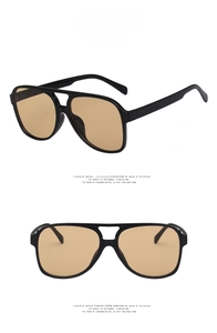 Detail view of glossy black double bridge aviator sunglasses with light tea lenses