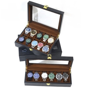 Close-up of black leather watch storage box with transparent window and gold metal buckle