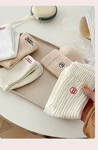 Vue détaillée des chaussettes en coton à côtes verticales avec broderies et texte soignés