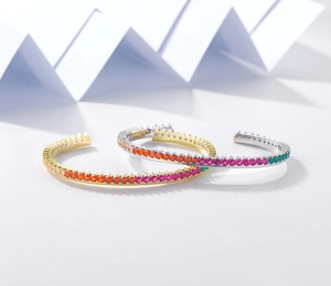 Close-up of gold and silver open bangles with colorful zircon row pavé setting