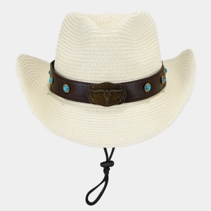 Close-up of cattle head emblem and turquoise studs on a western straw cowboy hat