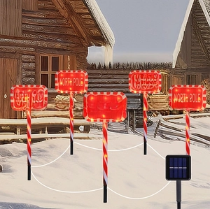Detail showing 5 solar candy cane path lights with glowing North Pole signs in the snow