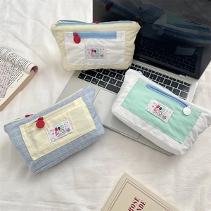 Detail of multi-compartment canvas pencil case with zipper pocket and art labels