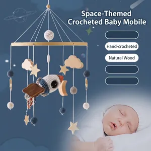 Space-themed handmade crochet baby crib mobile with wooden planets and rockets for nursery