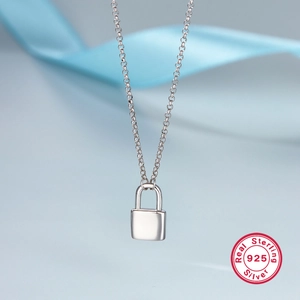 Minimalist S925 sterling silver solid padlock necklace on elegant blue silk backdrop