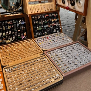 Outdoor market display showing a large collection of vintage style adjustable rings and jewelry
