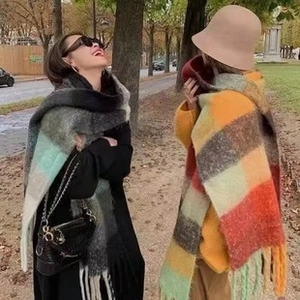 Outdoor lifestyle view of women wearing warm colorful plaid scarves with soft tassels