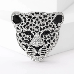 Dettaglio macro della spilla a leopardo argento con strass e macchie di smalto nero