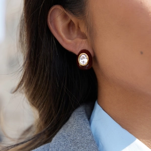 Detail of vintage teardrop earrings with red enamel and zircon on model's ear