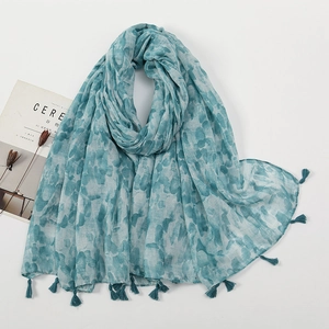 Detail of teal watercolor print scarf with lightweight fabric and fringe tassels
