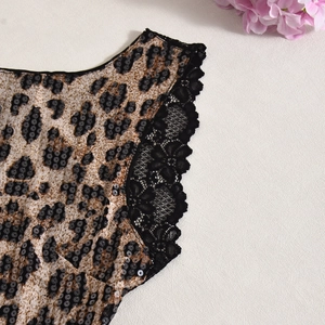 Gros plan sur le tissu à imprimé léopard avec bordure en dentelle noire et paillettes