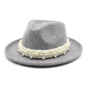 Primer plano de perlas blancas en sombrero fedora de lana gris con ala ancha