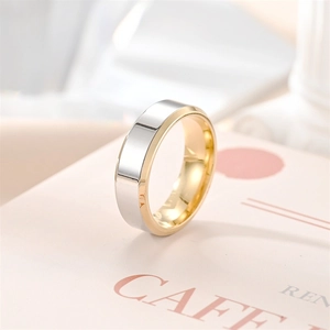 Primer plano detallado de un anillo minimalista de acero bicolor sobre fondo elegante