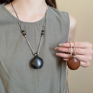 Detail of wax cord necklace with mini gourd wooden pendants and ethnic wood beads
