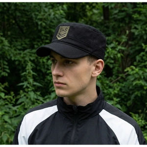 Detail of military style black flat top cap featuring green U.S. star embroidery logo
