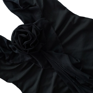 Détail d'une fleur de rose 3D en tissu sur une robe de soirée en maille noire