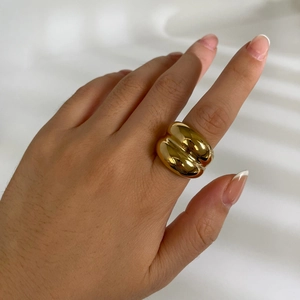 Polished 18k gold plated stainless steel chunky domed ring worn on a person's finger