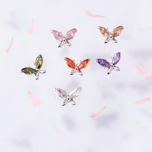 Detailed close-up of 3D butterfly nail charms with marquise cut stones in six vibrant colors