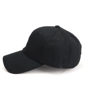 Detail view of black baseball cap with white cat embroidery on the side panel