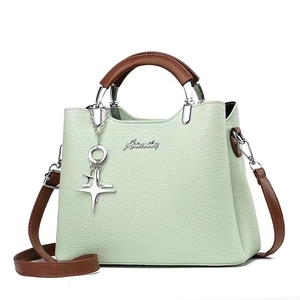Detail of mint green bucket bag with lychee texture leather and star charm