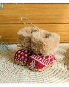 Close-up of red knitted Christmas boot ornaments with faux fur trim on wooden background