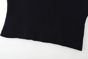 Gros plan sur la maille côtelée bleu foncé montrant la texture de l'ourlet et les coutures