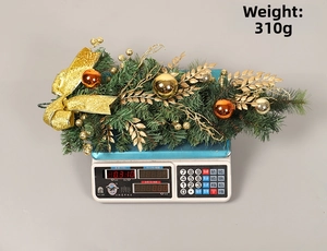 Macro view of golden Christmas swag hanging decoration on scale weighing 310g