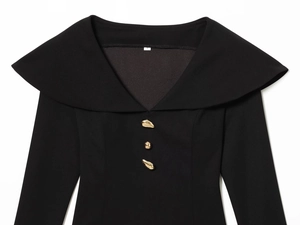 Close-up of elegant black dress with wide lapel collar and golden decorative buttons