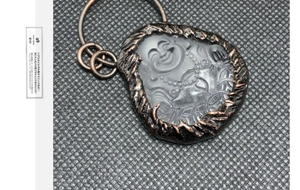 Makro-Detail von Kristall-Buddha-Anhänger mit Metallumrandung im Retro-Bronze-Design