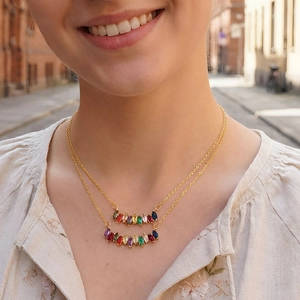 Double-layered gold necklace with colorful marquise-cut zircon stones worn by a model