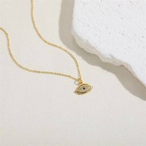 Macro detail of Evil Eye pendant with zircons on 14K gold plated chain necklace