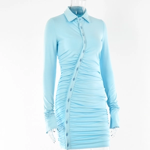 Détail d'une robe bleu clair à manches longues avec boutons et texture plissée chic