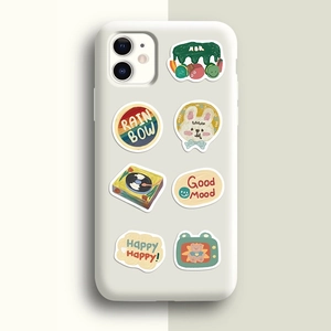 Détail des autocollants mignons sur coque en silicone blanc mat avec un fond aux tons pastels