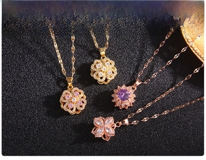 Detail of four rotating clover pendants with colorful zircons on black leather
