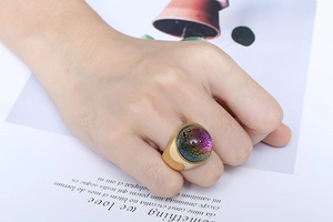 Detailed close-up of a large gold stainless steel ring with colorful glass foil inlay