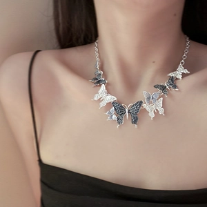 Y2K style butterfly necklace with black and silver pendants on a thick link chain