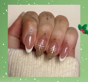 Macro detail of French white press-on nails with gold glitter and Christmas snowflake patterns