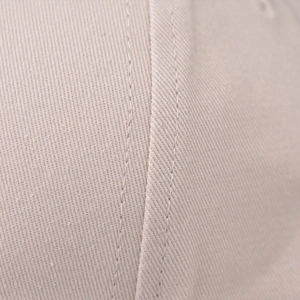 Vista dettagliata del tessuto twill di cotone beige con doppia cucitura sulla corona