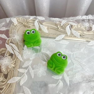 Detail of cute green frog jewelry boxes on vintage gold frame with lace and mirror