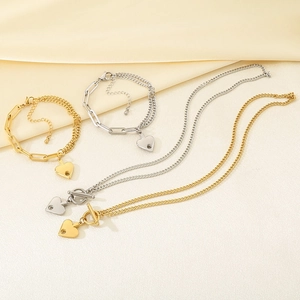 Dettaglio di collane e bracciali in oro 18k e argento con pendenti a cuore su seta