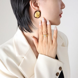 Retro hammered gold earrings with brown enamel and zircon ring on a model