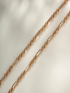 Detailed macro view of a gold-plated geometric link chain necklace with polished finish