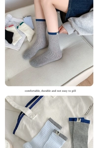 Close-up of color-block knit socks with cute bear labels and ribbed vertical textures