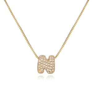 Macro shot of gold letter N pendant with pavé set sparkling crystals on box chain necklace