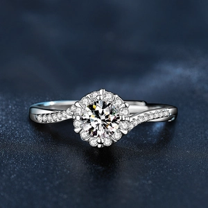 Close-up of sparkling moissanite snowflake ring with a twisted pavé band on blue background