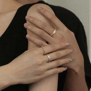 Rose gold couple rings featuring minimalist zircon row stones on a pair of hands