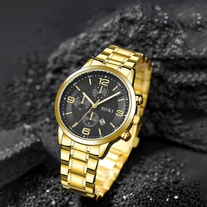 Business men's watch with gold steel strap and black dial on dark volcanic rock