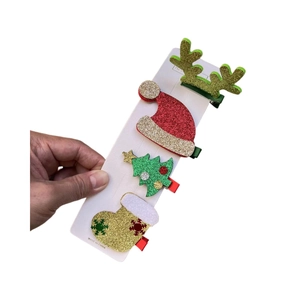 Gros plan de barrettes de Noël scintillantes avec renne, sapin et bonnet de Noël