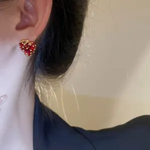 Sweet strawberry fruit stud earrings in red enamel with golden leaf accents for women