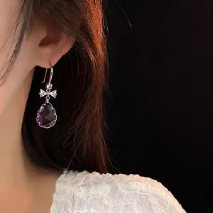 Boucles d'oreilles pendantes violettes avec nœud argenté et cristaux étincelants